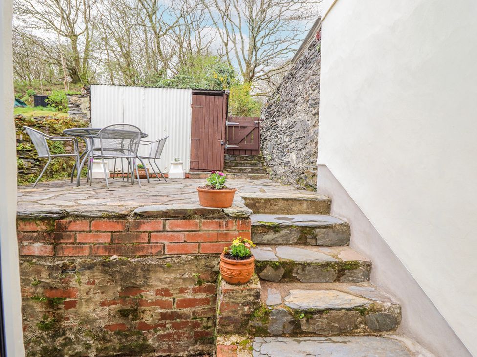 A garden with stone steps and a table and chairs at 12 Glyn Terrace Borth-Y-Gest