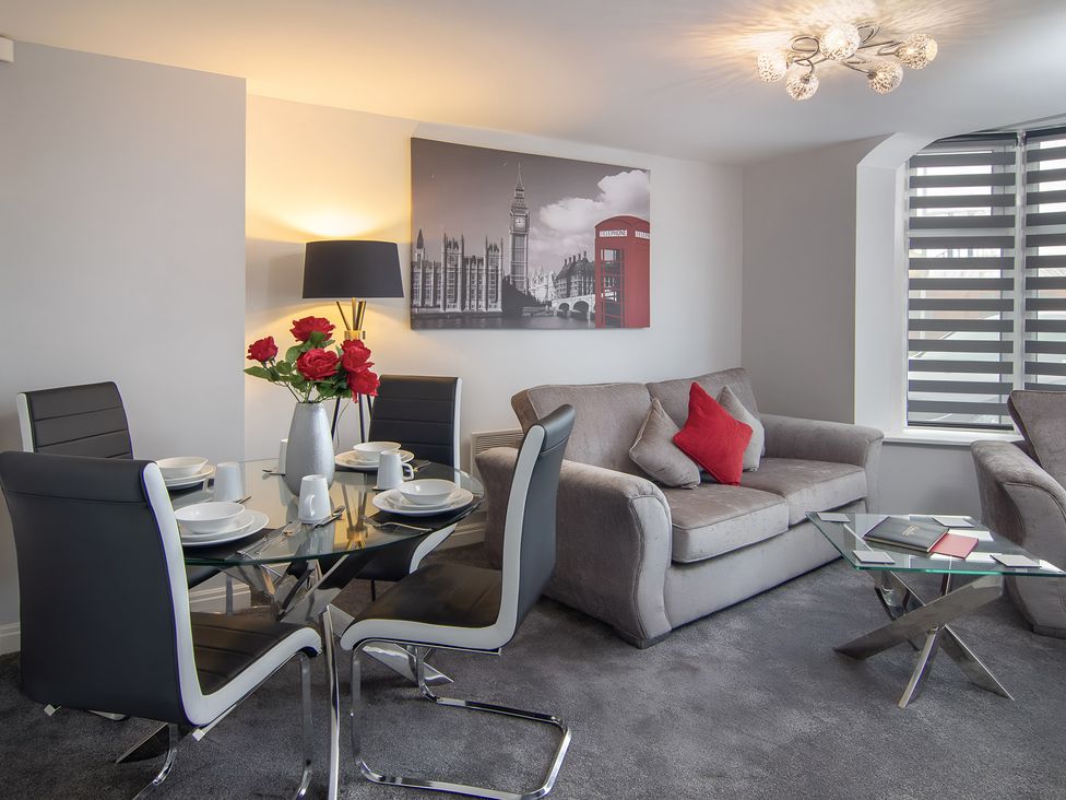 A living room with a dining area and wall art at Apartment 1 in Blackpool