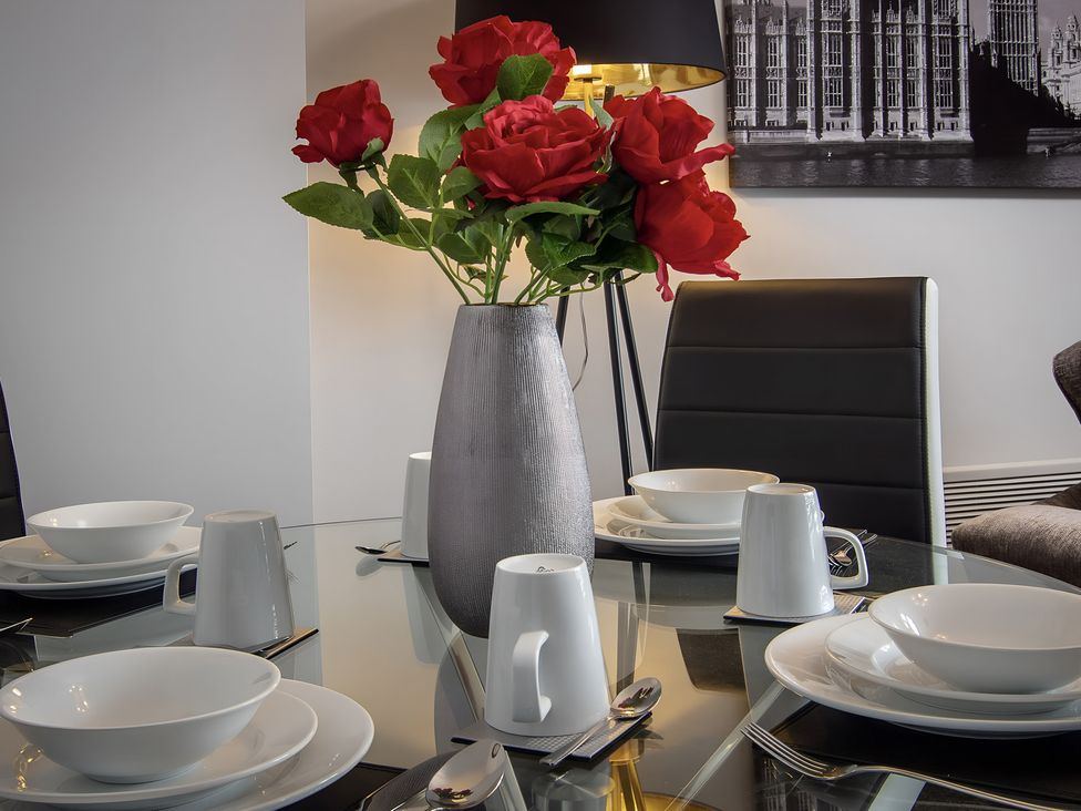 A dining room with a table set and flowers at Apartment 1 in Blackpool