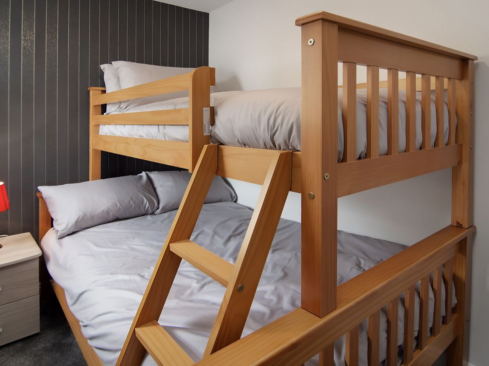 A bunk bed with bedding and a nightstand at Apartment 1 in Blackpool