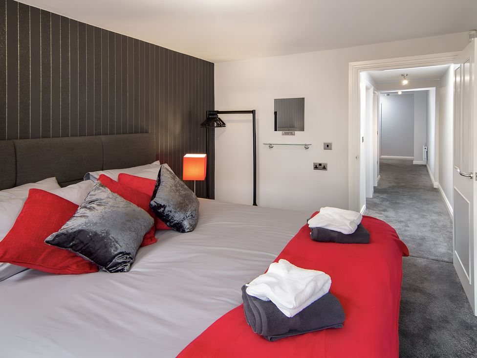 A bedroom with a bed and towels at Apartment 1 in Blackpool