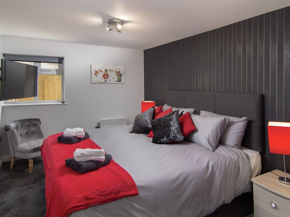 A bedroom with a bed and chair at Apartment 1 in Blackpool