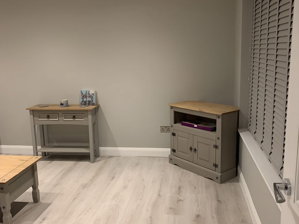 A living room with a side table and a cabinet at 43 Goose Green Road King's Lynn