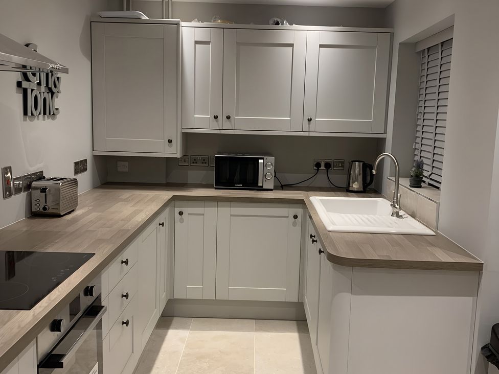 A kitchen with cabinets and appliances at 43 Goose Green Road in King's Lynn