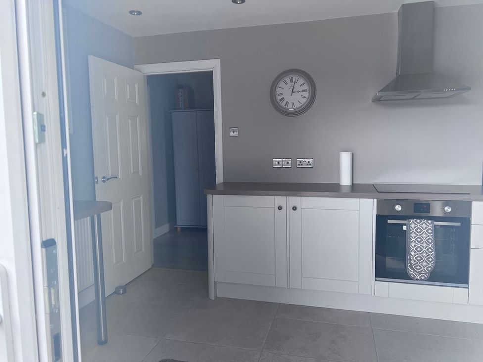 A kitchen with an oven and clock at 43 Goose Green Road in King's Lynn