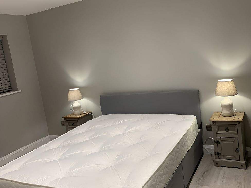 A bedroom with a bed and bedside tables at 43 Goose Green Road in King's Lynn