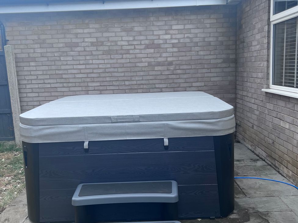 A hot tub with cover and steps in an outdoor area at 43 Goose Green Road King's Lynn