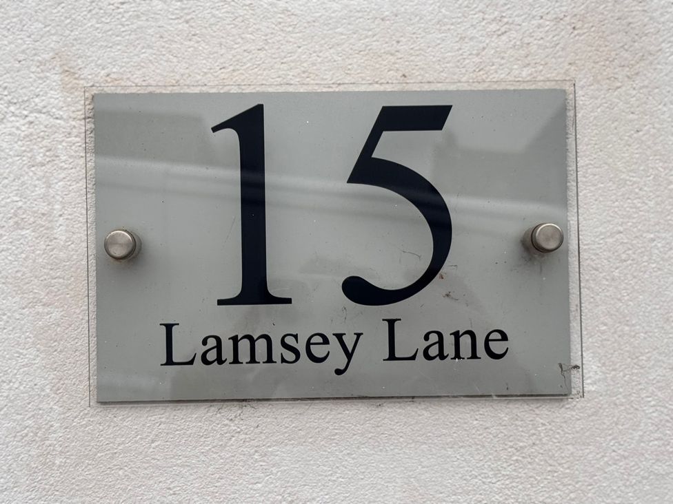 A sign displaying the address 15 Lamsey Lane