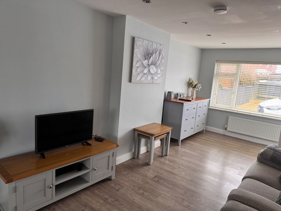 A living room with a television and furniture at 15 Lamsey Lane in King's Lynn