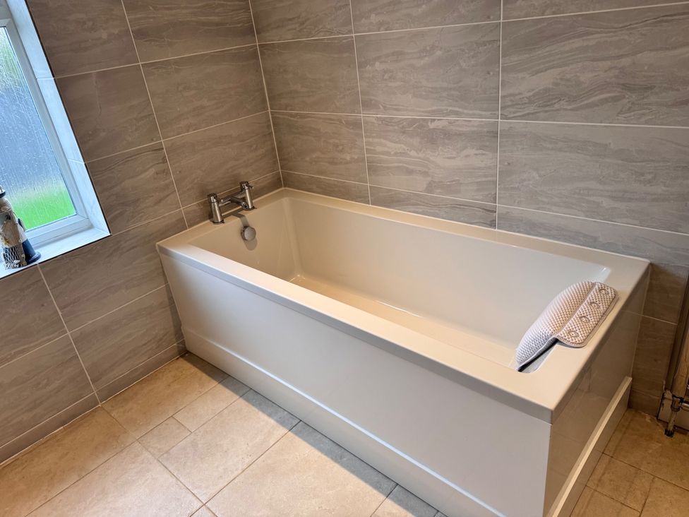 A bathroom with a bath tub and faucet at 15 Lamsey Lane King's Lynn