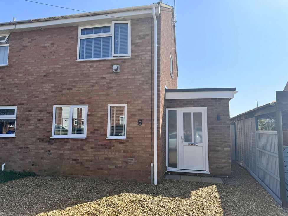 An exterior view of a house with windows and a door at 22 Sandringham Drive in King's Lynn