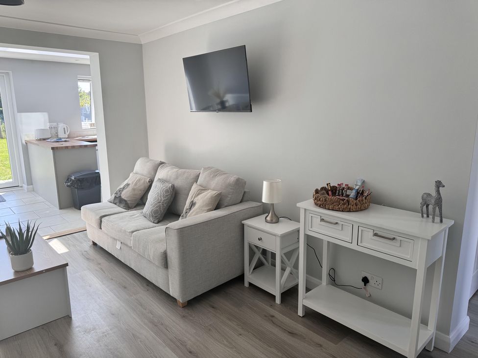 A living room with a sofa and television at 22 Sandringham Drive in King's Lynn
