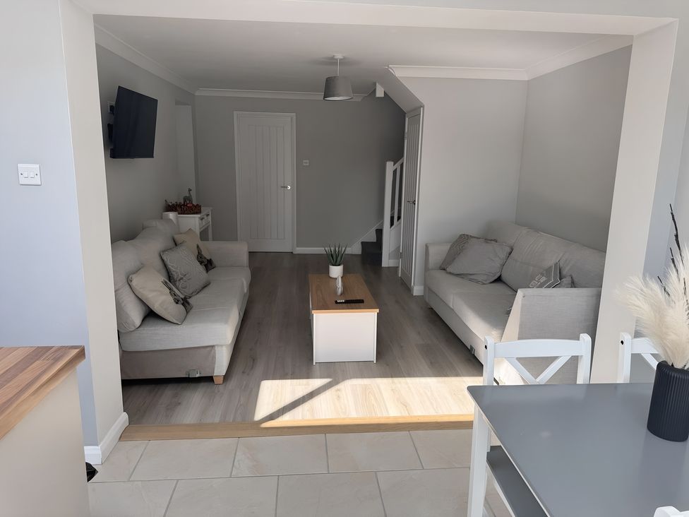A living room with sofas and a table at 22 Sandringham Drive in King's Lynn