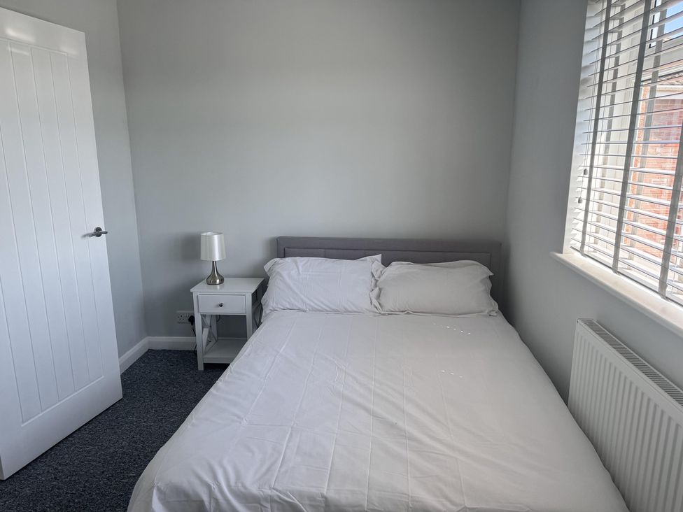 A bedroom with a bed and bedside table at 22 Sandringham Drive in King's Lynn