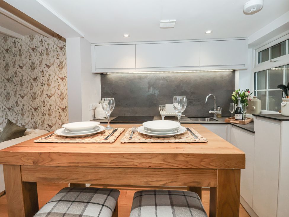 A kitchen with a wooden table set for two at No.4 Main Street Hull