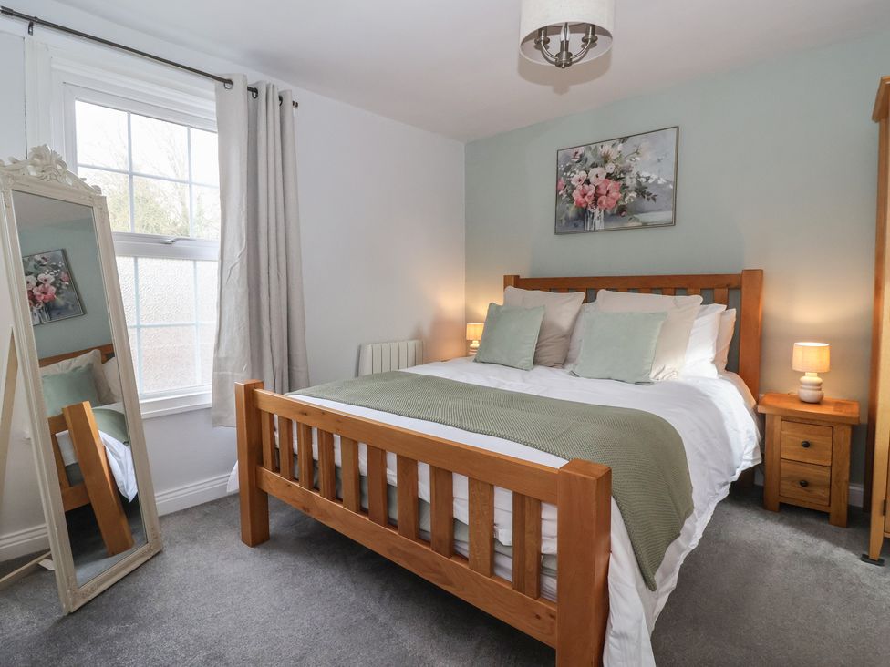 A bedroom with a bed and a mirror at No.4 Main Street in Hull