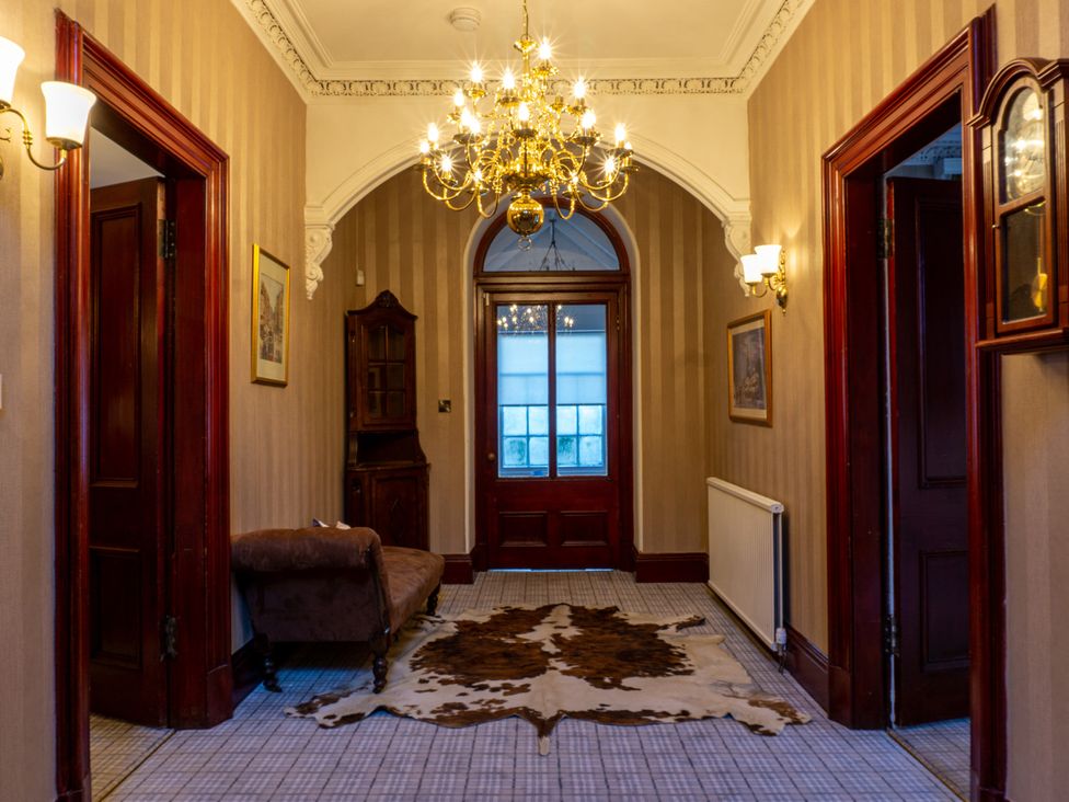 A hallway with a chandelier and a sofa at Newton Manor House in Cupar