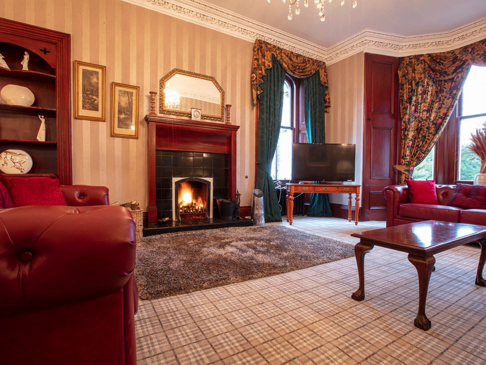 A living room with a fireplace and sofa at Newton Manor House in Cupar