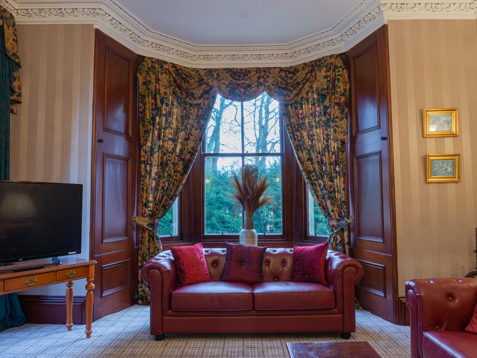 A living room with a sofa and television at Newton Manor House in Cupar