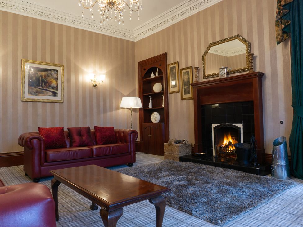 A living room with a sofa and a fireplace at Newton Manor House in Cupar