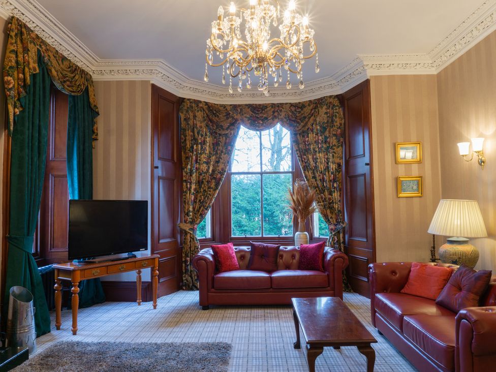A living room with a television and sofa at Newton Manor House in Cupar