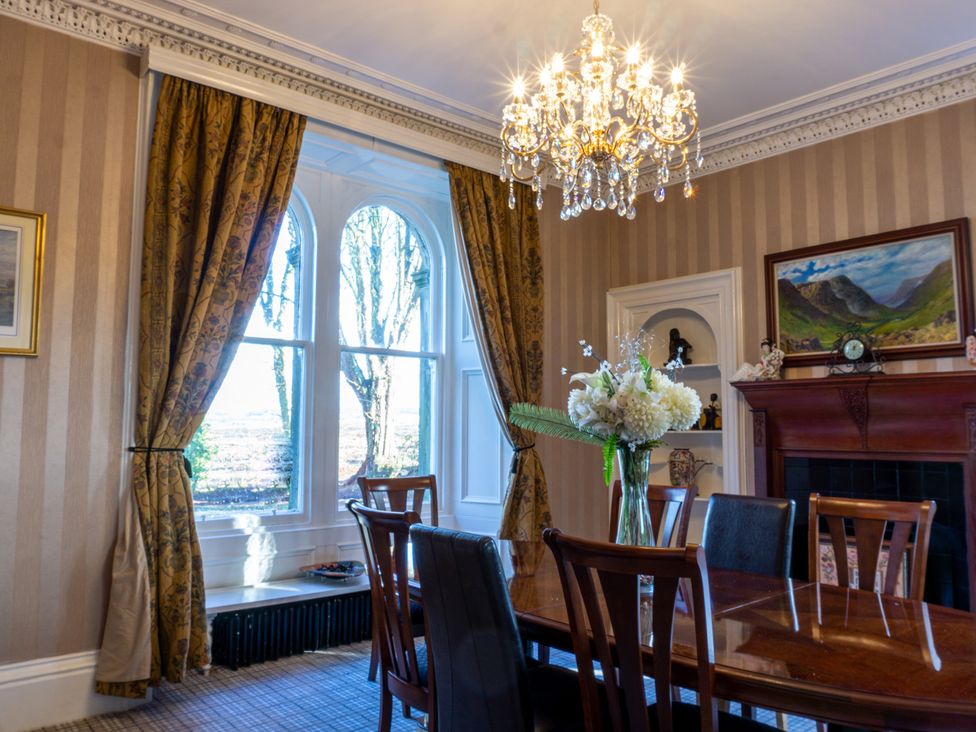 A dining room with chandelier and dining table at Newton Manor House in Cupar