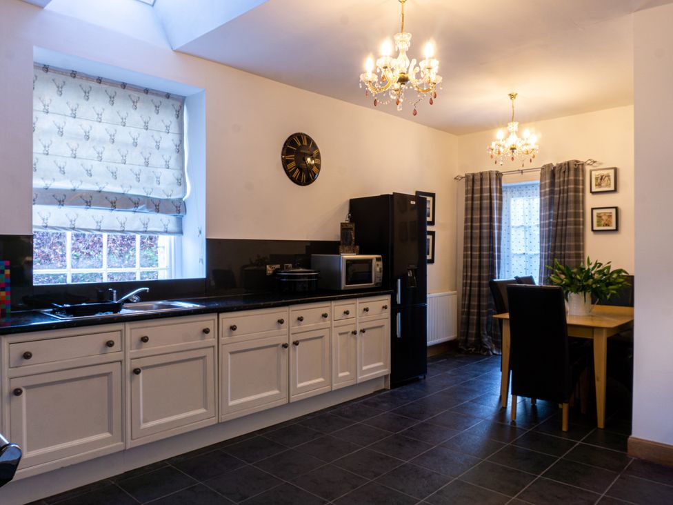 A kitchen with cabinets and a table at Newton Manor House in Cupar