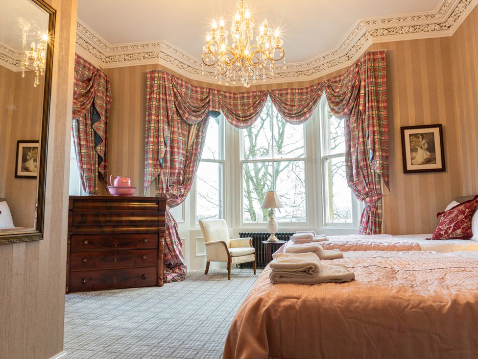 A bedroom with a bed and dressing table at Newton Manor House in Cupar
