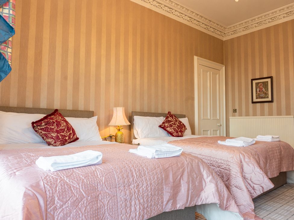 A bedroom with two beds and a lamp at Newton Manor House in Cupar