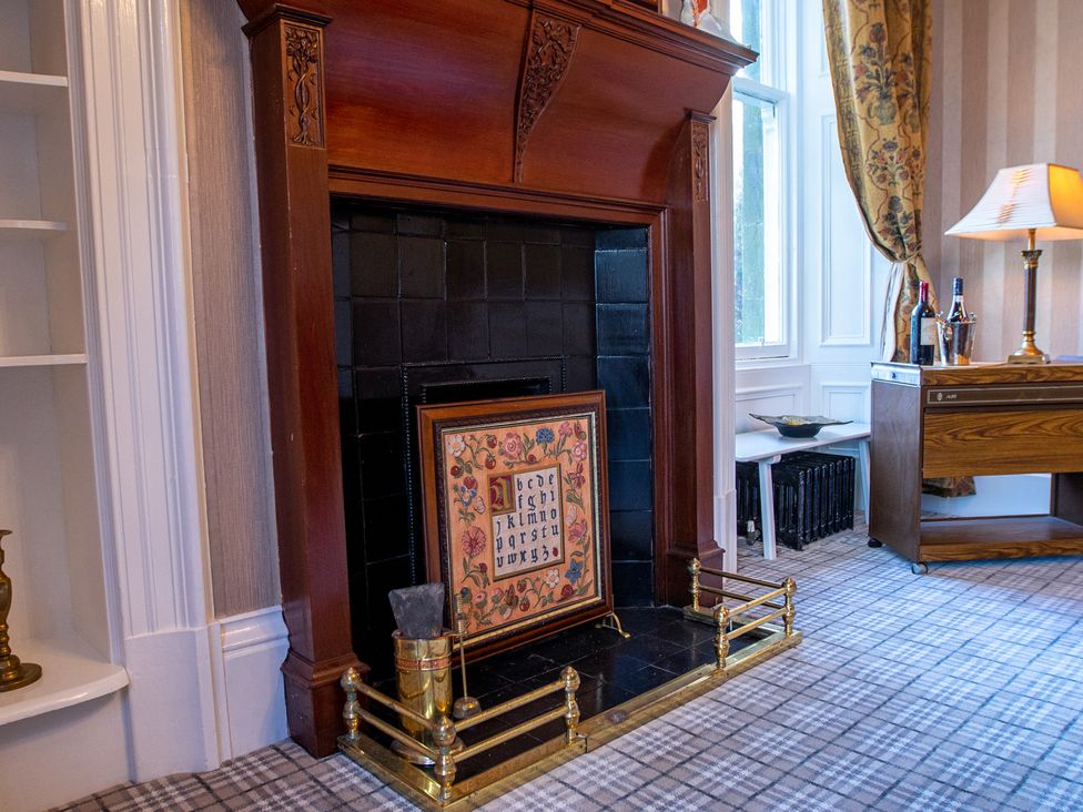 A fireplace with artwork above in the living room at Newton Manor House Cupar