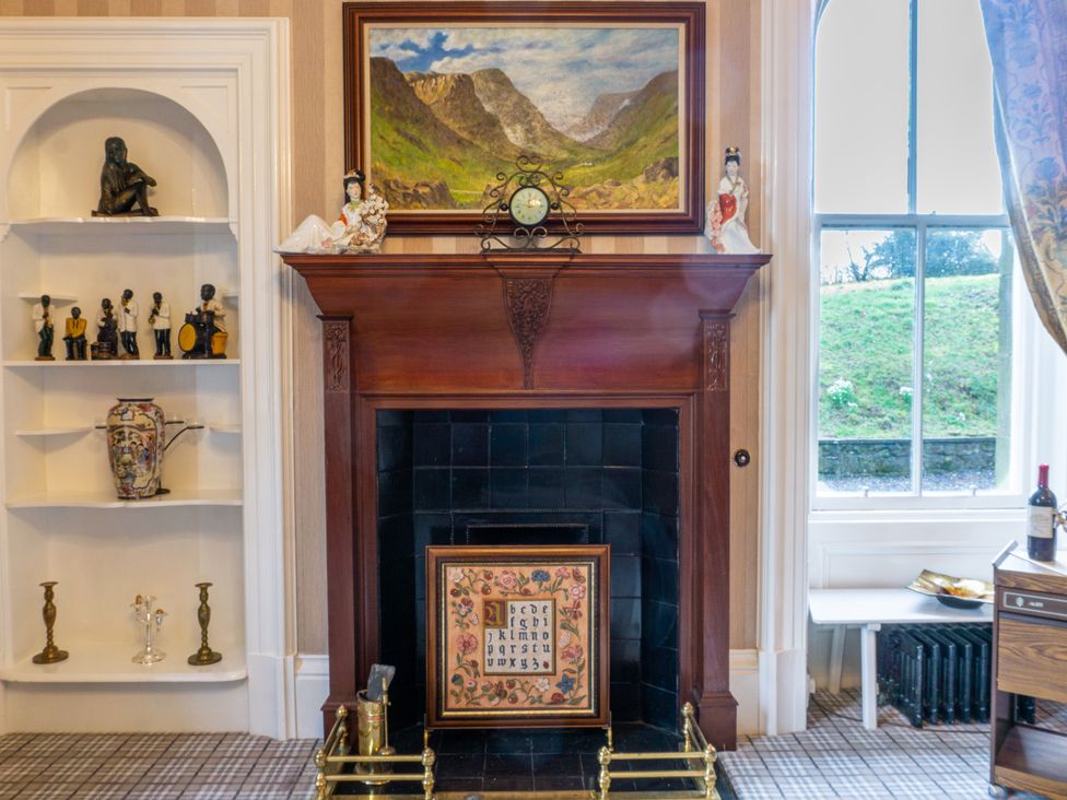 A living room with a fireplace and decorative items at Newton Manor House in Cupar