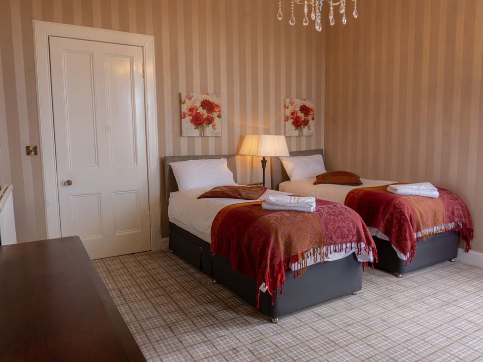 A bedroom with two beds and a lamp at Newton Manor House in Cupar