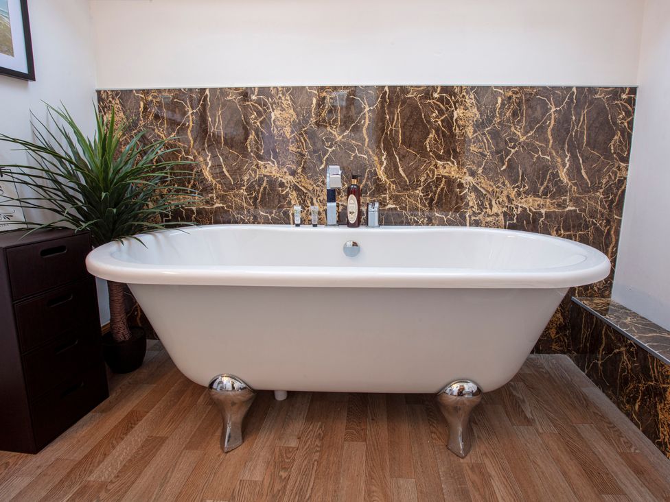 A bathroom with a bathtub and a plant at Newton Manor House in Cupar