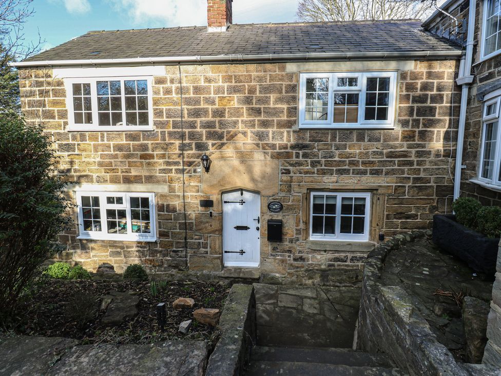 A front view of a stone cottage with a door and windows at Lake side cottage