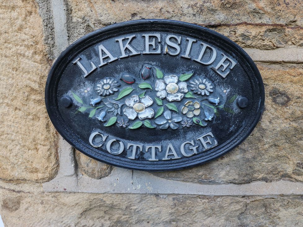 A plaque with the name Lakeside Cottage mounted on a stone wall