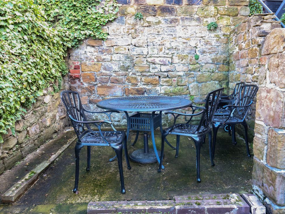 A garden with a table and chairs at Lake side cottage