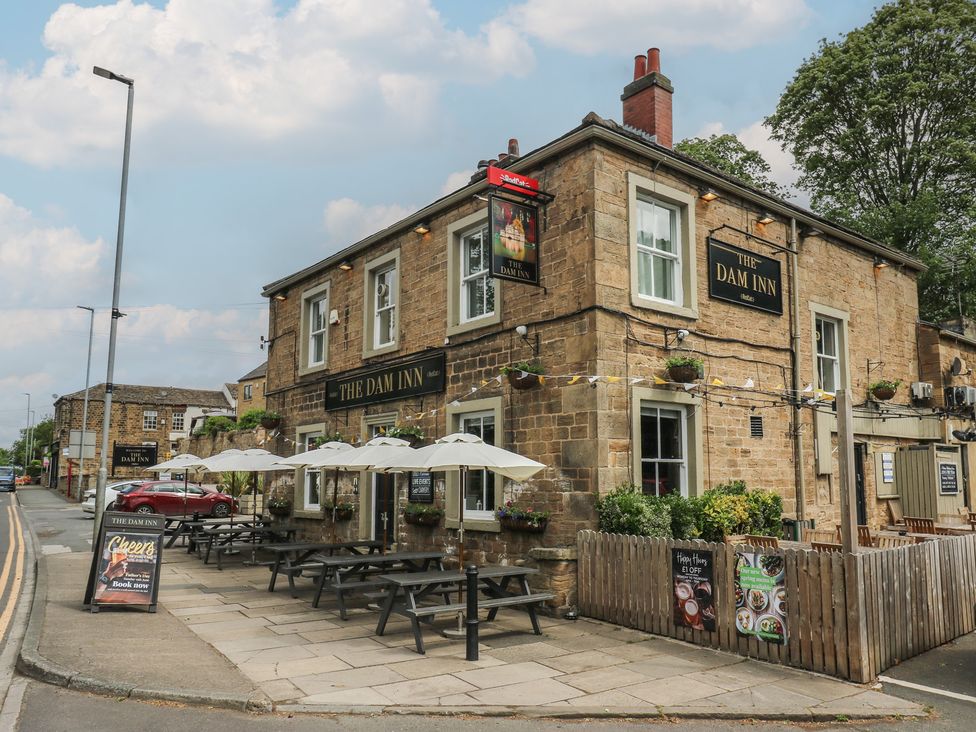 An outdoor pub with tables and umbrellas at The Dam Inn