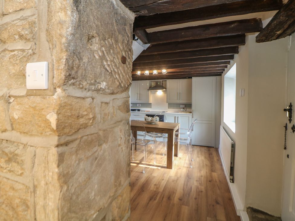 A kitchen with a wooden table and chairs at Lake Side Cottage in Wakefield