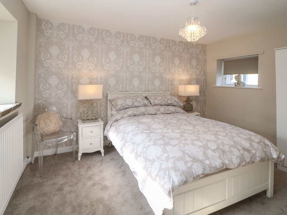A bedroom with a bed and nightstands at Lake Side Cottage in Wakefield
