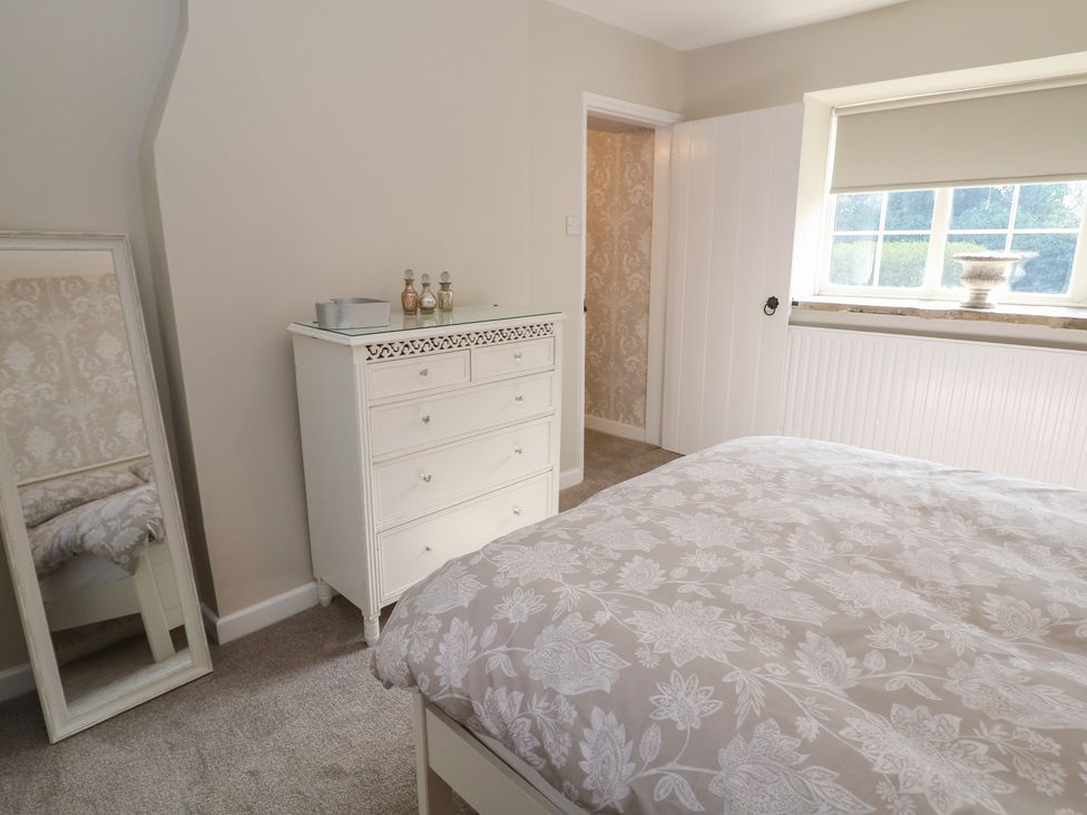 A bedroom with a dresser and mirror at Lake Side Cottage in Wakefield