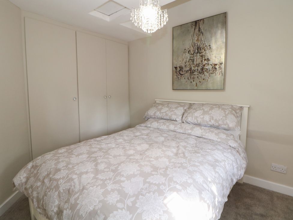 A bedroom with a bed and wardrobe at Lake Side Cottage in Wakefield