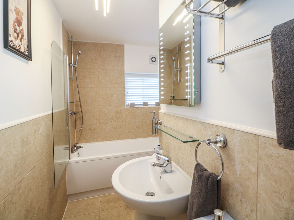 A bathroom with a sink, bathtub, and shower at Lake Side Cottage in Wakefield