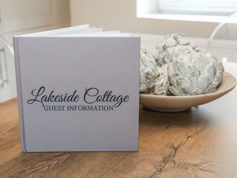 A guest information book and decorative items in the dining room at Lake Side Cottage in Wakefield