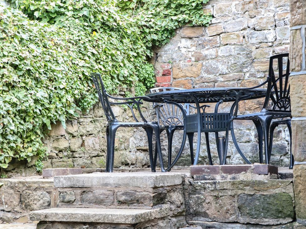 A table and chairs set in an outdoor area at Lake Side Cottage in Wakefield