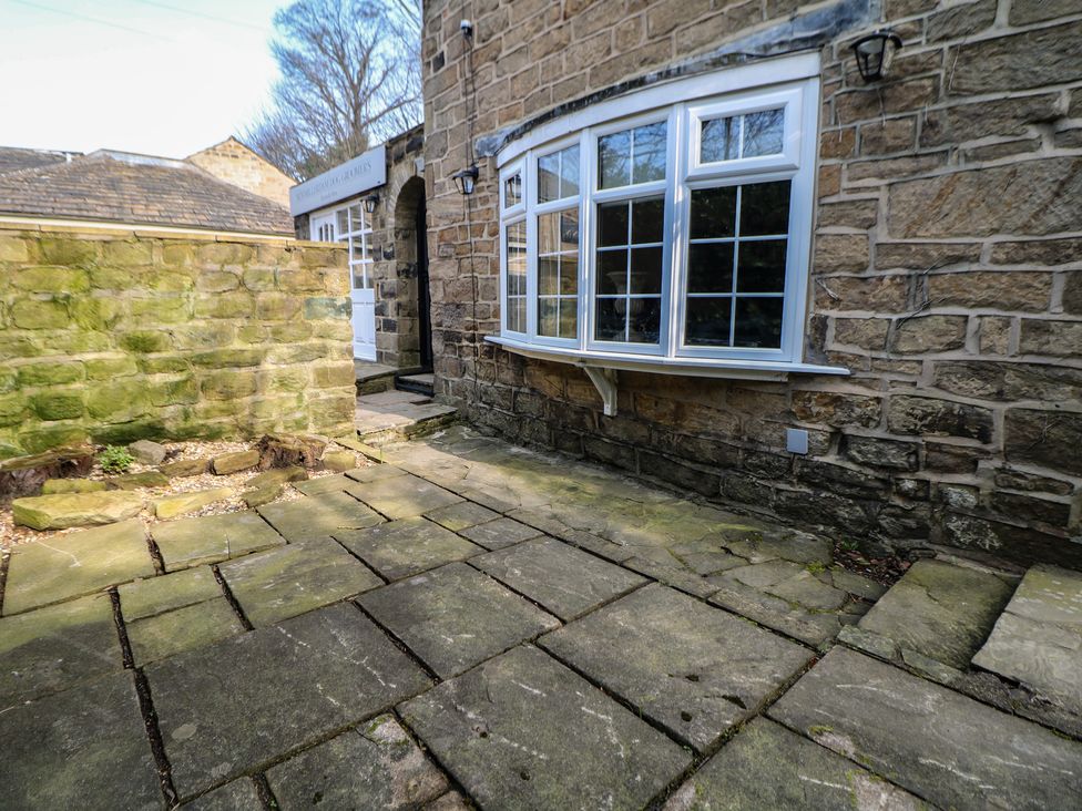 An outdoor area with stone pavement and a window at Lake Side Cottage in Wakefield
