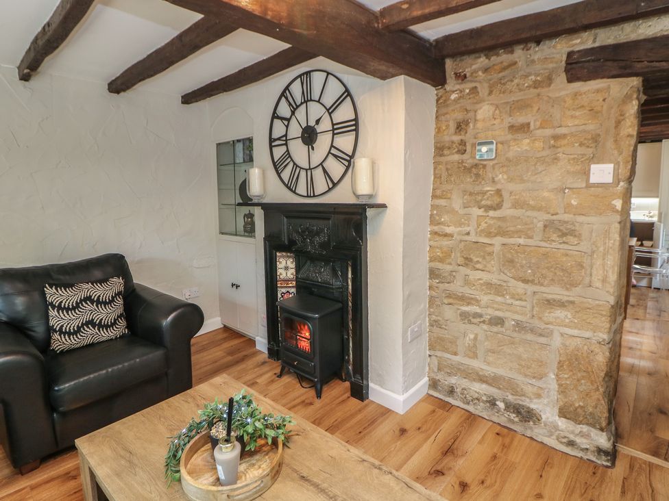 A living room with a sofa and fireplace at Lake Side Cottage in Wakefield