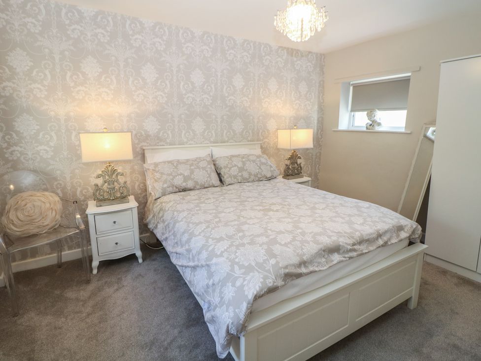 A bedroom with a bed and bedside tables at Lake Side Cottage in Wakefield