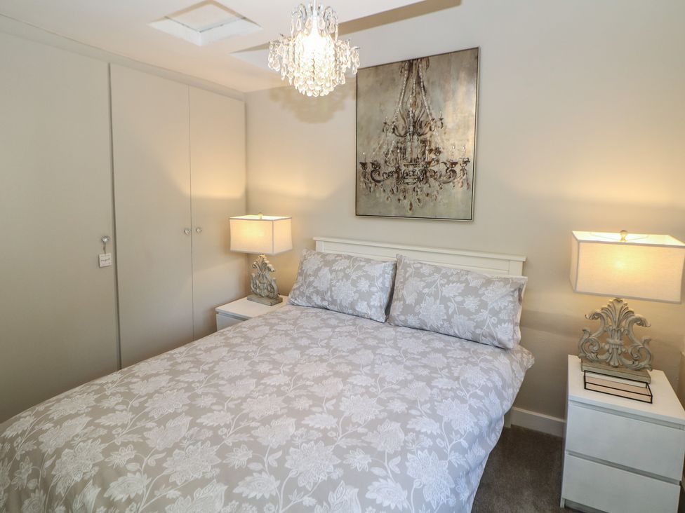 A bedroom with a bed and bedside tables at Lake Side Cottage in Wakefield