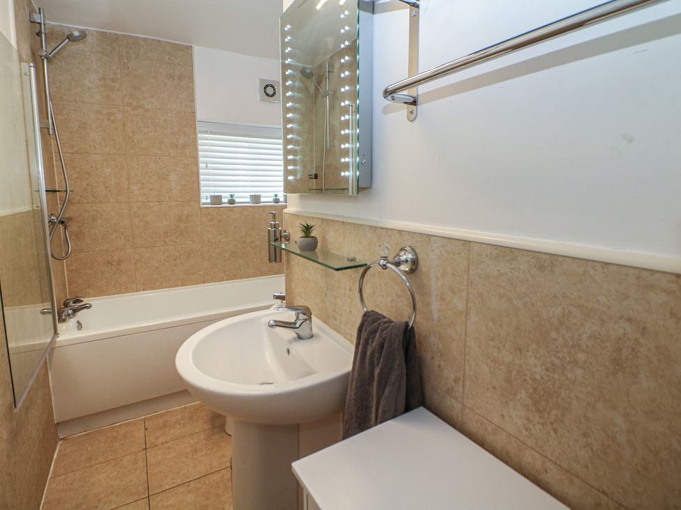 A bathroom with a bathtub and sink at Lake Side Cottage in Wakefield