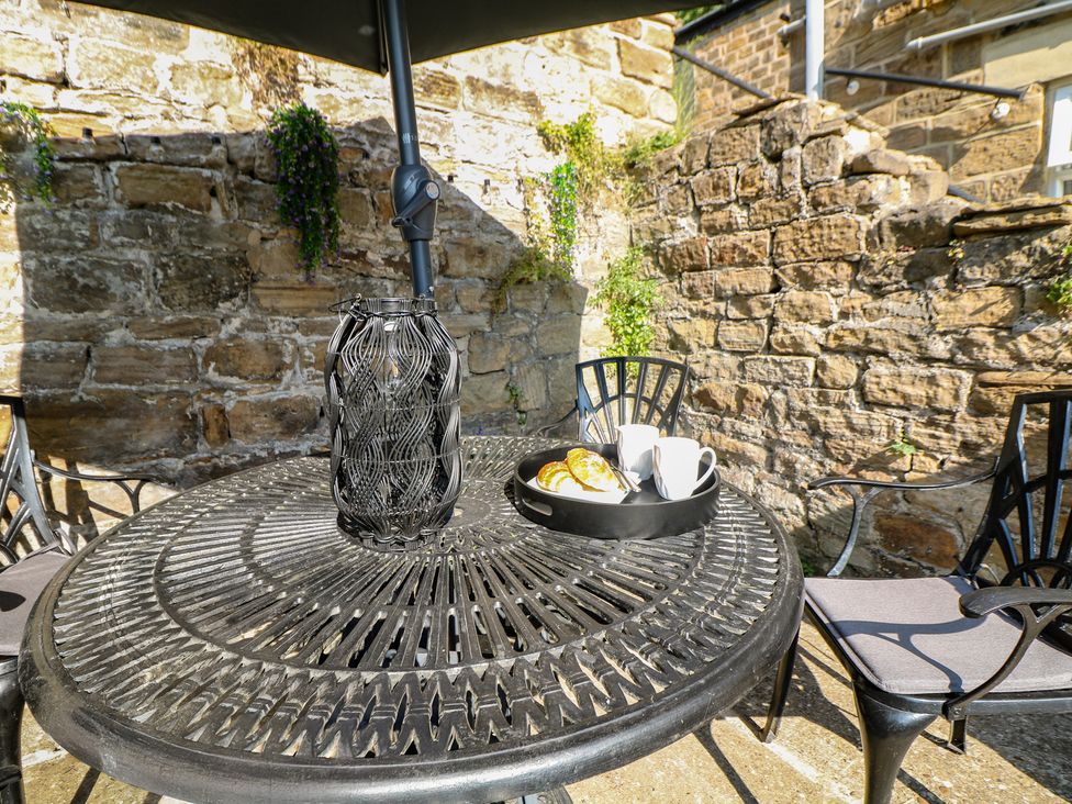A table with chairs and cups on a plate at Lake Side Cottage Wakefield